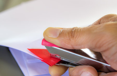 Hands with papers and stapler in office