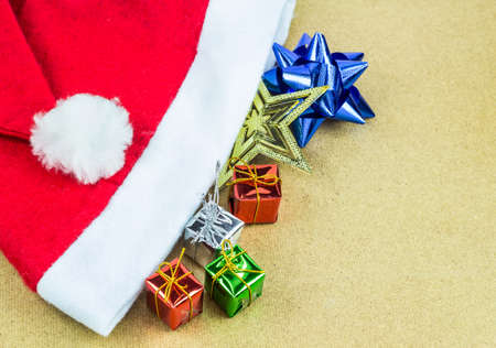 Red Santa Claus hat and gift box on wooden table backgroundの写真素材
