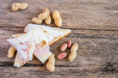 Close up of fresh and tasty sandwich and peanut on wooden table