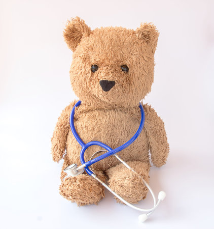 Blue stethoscope and teddy bear on a white backgroundの写真素材