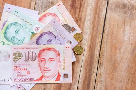 Singapore money on wooden table background, various of singapore dollar banknoteの写真素材
