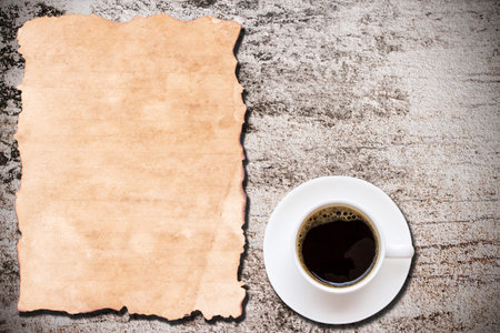 Old paper and cup of coffee on grunge background with copy space