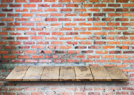 Empty top wooden shelves and stone brick wall background. For product displayの写真素材