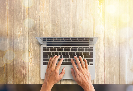 Top view of business man hand working with laptop computer on wooden desk.Business concept. Double exposureの写真素材