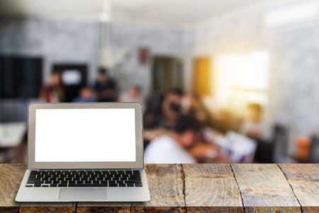 Blank screen laptop on wooden shelves with blurred office background. Put of display, montage of product. Business concept.の写真素材