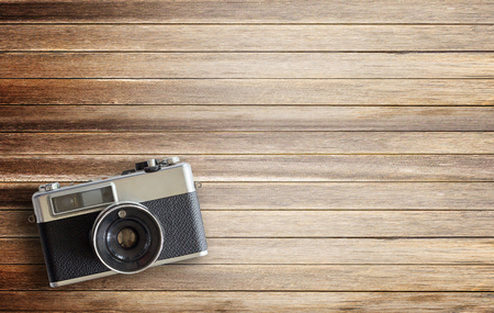 Retro camera on wood table background, vintage color tone. top view with copy space for useの写真素材