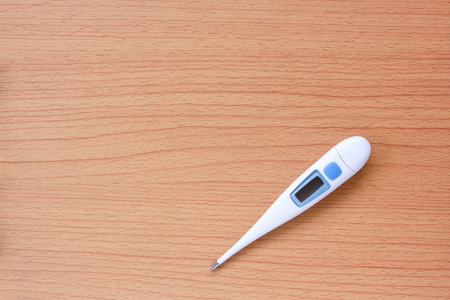 Thermometer on wooden table top view with copy space for design