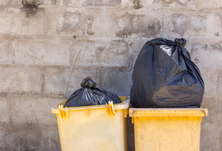 Yellow garbage and trashcan on the streetの写真素材