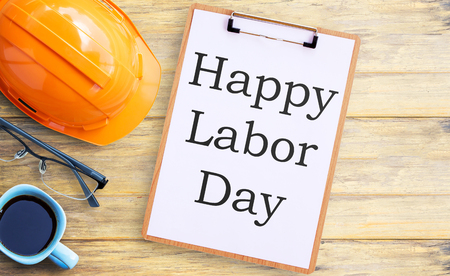 Top view with orange safety helmet,glasses,clipboard and cup of coffee on old wooden table background. space for use and any design. Business and labor day concept.の写真素材