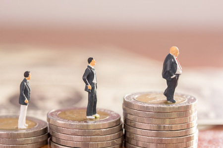 Miniature people : Businessman figures standing on the coin with blurred  background. money and financial concept. copy space for use as business background or wallpaper.の写真素材