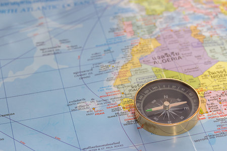 Close up magnetic compass on a world map conceptual of global travel , tourism and exploration....