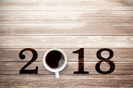 2018 text and cup of coffee on old wooden table in vintage style for new year concept. Copy space for use.の写真素材