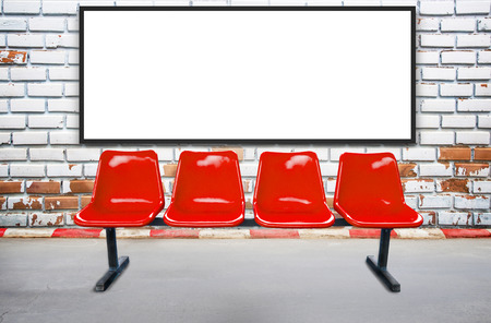 Blank advertising billboard or wide screen television and red chair with old vintage buildings exterior brick wall background, commercial and marketing concept, copy space for text or media content.の写真素材