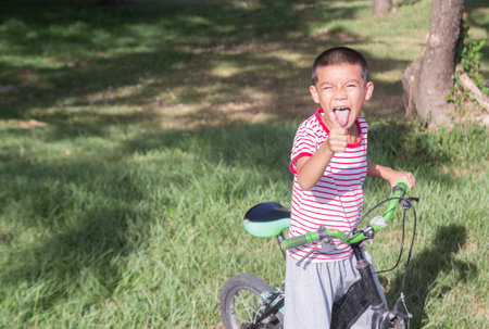 Preteen cute asian boy ride a bicycle in a park.の写真素材