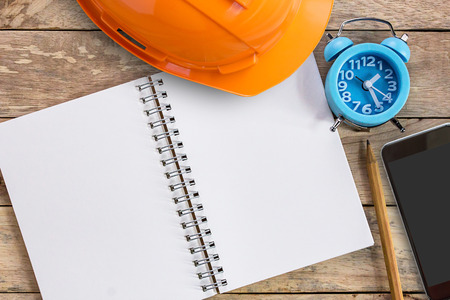 Top view with orange safety engineer helmet and notebook or notepadの写真素材