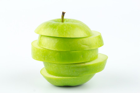 Close up green apple sliced isolated on whiteの写真素材
