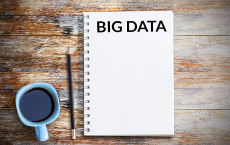 Text with big data and coffee cup, notebook,pencil on grunge wooden table. Top view with copy space (selective focus). Office desk table,food and drink ,business concept.の写真素材