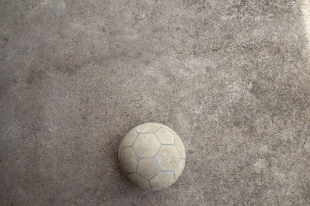 Old soccer ball on the cement floor. Top view with copy space for design.の写真素材