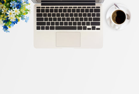 Office desk with laptop computer,flower and cup of coffee on office table in office workplace. Business and financial concept. Top view with copy space.の写真素材