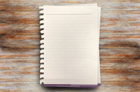 Top view with three white paper on wood table in office workplace. Blank Pad of Paper ready for your...