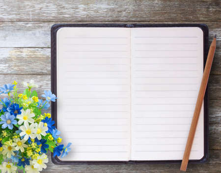 Top view with flower pencil and notebooks on wood table. Copy space for your design.の写真素材