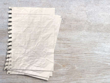 White paper on wood table background. Top view with copy space for your design.の写真素材