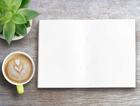 Blank notebook,calculator,earphone and cup of coffee with flower on wood table background. Top view with copy space. Business and financial concept. Freelance and work from home ideas.の写真素材