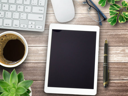 Business office desk design concept. Wood office table with glasses, cup of coffee, tablet and...