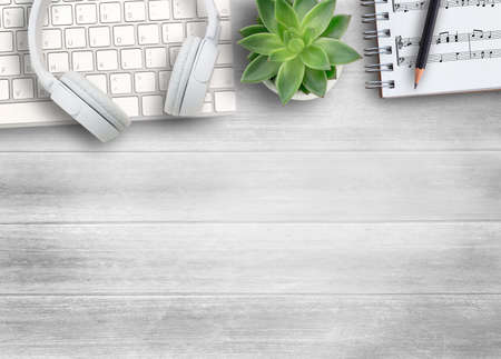 White head phone,keyboard  and sheet music on white wood table background.Top view with copy space for use.の写真素材