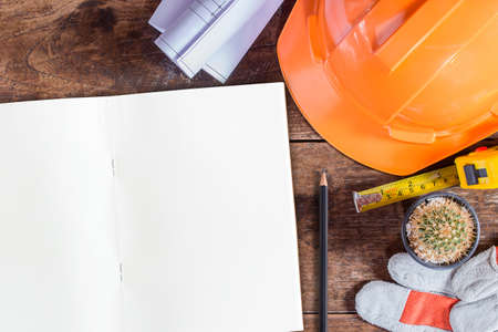 Labor day concept.Construction safety equipment and blank notebook or notepad on wooden table. top view with copy spaceの写真素材