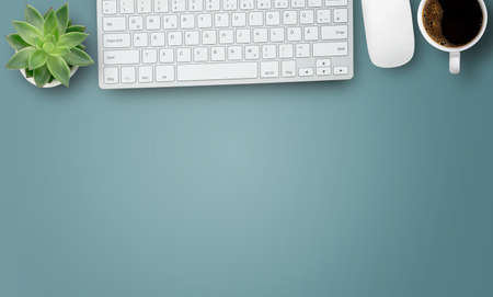 Office desk with stationary,keyboard,notebook,calculator,pencil,coffee and flower on blue table background. Top view with copyspace. Concept for business.の写真素材