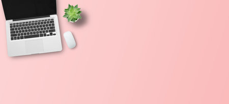 Top view with laptop computer on pink table background. Panoramic banner for business marketing design. copy spaceの写真素材