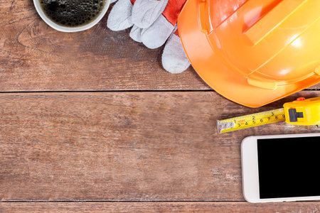 Labor day concept.Construction safety equipment and blank notebook or notepad on wooden table. top...