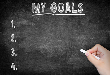MY GOALS text concept on blackboard or chalkboard. Hand writing my goals with white chalk on black...