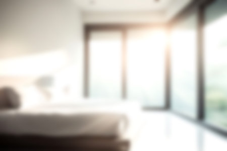 Blur modern bedroom at home with morning soft sunlight at big window for background usage. blur interior background concept. white, bright tone.の写真素材