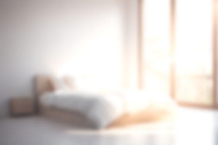Blur modern bedroom at home with morning soft sunlight at big window for background usage. blur interior background concept. white, bright tone.の写真素材