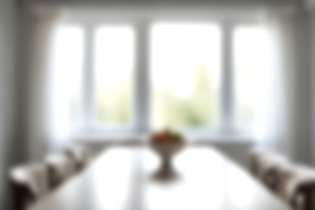 Blur modern dining room at home with soft sunlight at big window for background usage. blur interior...