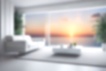 Blur modern livingroom with sea sky and soft sunlight at big window for background usage. blur interior background concept. white and bright tone. Business concept.の写真素材