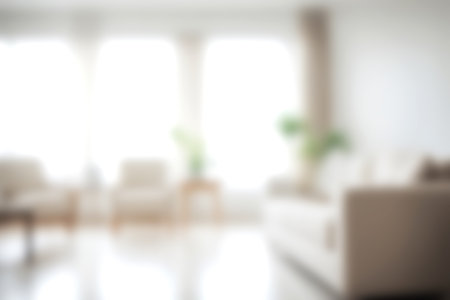 Blur modern livingroom at home with soft sunlight at big window for background usage. blur interior background concept. white and bright tone. Business concept.の写真素材