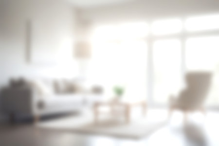 Blur modern livingroom at home with soft sunlight at big window for background usage. blur interior background concept. white and bright tone. Business concept.の写真素材