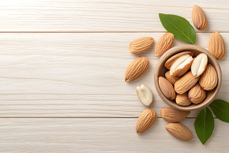 Bowl with tasty almond nuts on white wooden table, top viewの写真素材