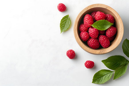 Fresh raspberries in wooden bowl on white background. Top view, copy space