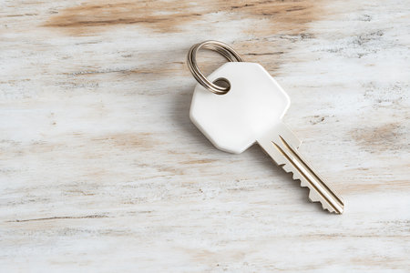 Key ring on white wooden background, close-up, copy spaceの写真素材