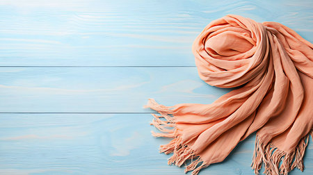 Orange scarf on light blue wooden table, flat lay. Space for textの写真素材