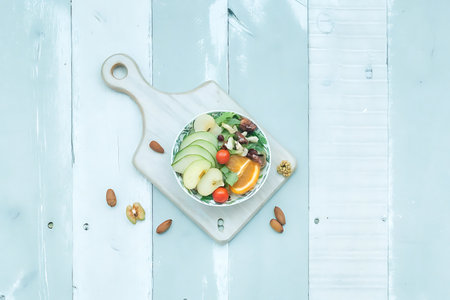 Salad with avocado, cucumber, tomato and almond on wooden boardの写真素材