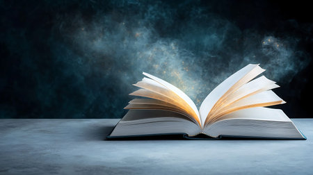 Open book with light coming out of pages on dark blue background.