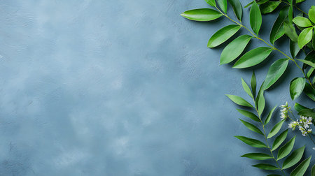 Green leaves on blue background. Flat lay, top view, copy space