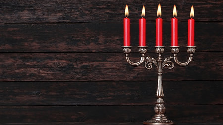 Hanukkah menorah with burning candles on dark wooden backgroundの写真素材