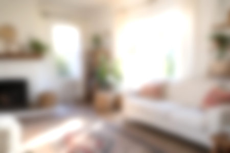 A bright and cozy living room featuring natural light, lush plants, and comfortable seating creates...