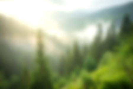 Discover a serene blurred landscape featuring misty mountains and lush green forests bathed in soft natural light. Perfect for evoking tranquility.の写真素材